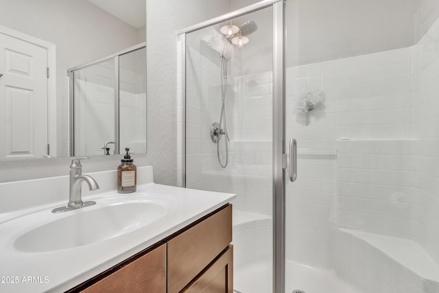 bathroom featuring vanity and a shower with shower door