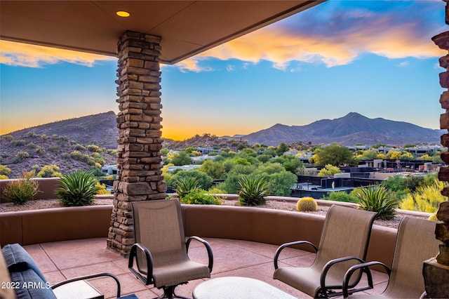 patio terrace at dusk featuring a mountain view