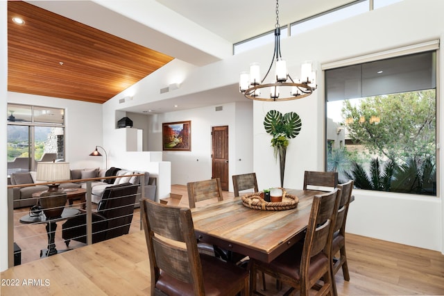 dining space featuring wood ceiling, a chandelier, vaulted ceiling, and light wood-type flooring