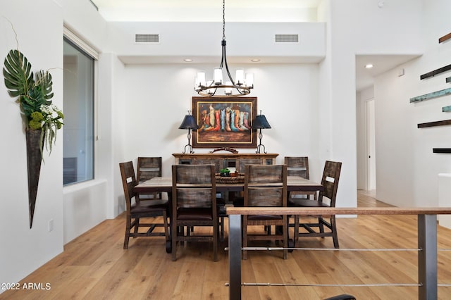 dining area featuring light hardwood / wood-style flooring and a notable chandelier