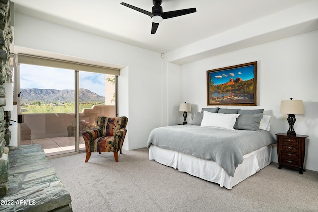 carpeted bedroom featuring a mountain view, access to exterior, and ceiling fan