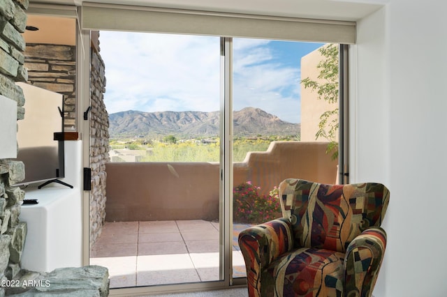 doorway to outside featuring a mountain view and light tile patterned floors