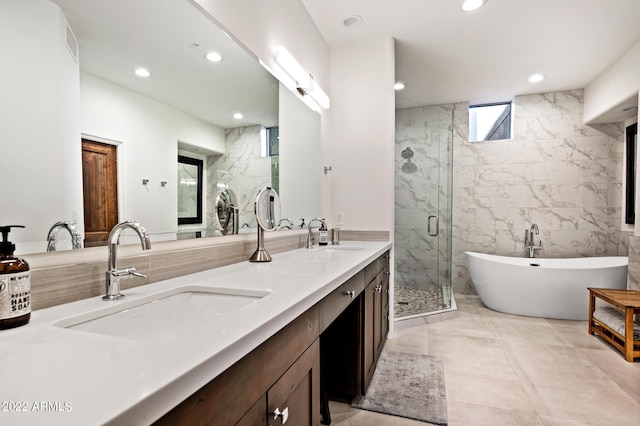 bathroom featuring vanity, independent shower and bath, and tile walls