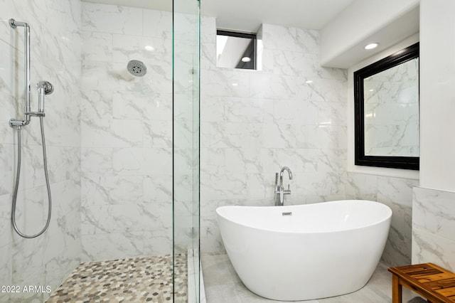 bathroom featuring separate shower and tub and tile walls