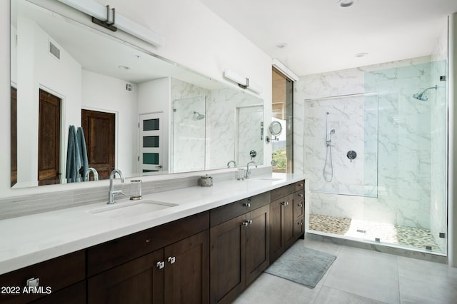 bathroom featuring vanity, tile patterned flooring, and a tile shower