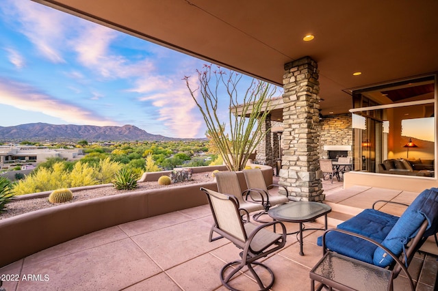 patio terrace at dusk featuring a mountain view