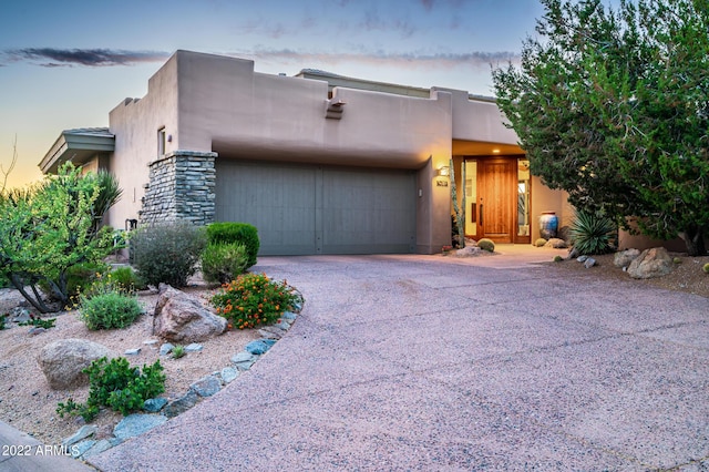 pueblo-style house featuring a garage