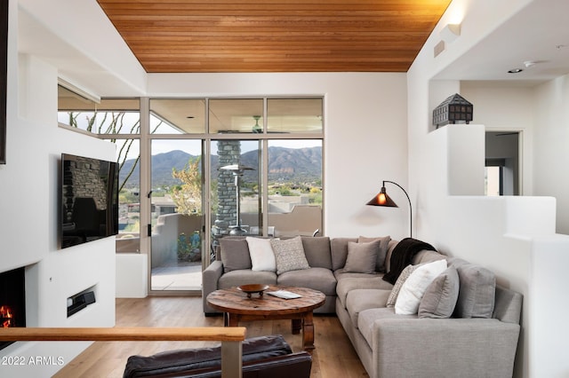 living room featuring vaulted ceiling, hardwood / wood-style floors, wooden ceiling, and ceiling fan