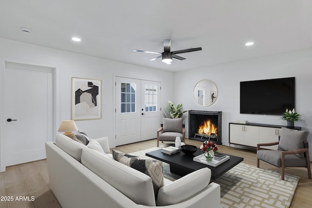 living room with ceiling fan, french doors, and light hardwood / wood-style floors