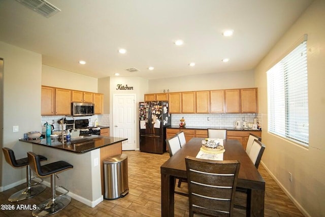 19886 W Woodlands Ave, Buckeye, AZ 85326 - kitchen featuring freestanding refrigerator, stainless steel microwave, range with gas cooktop, backsplash, and recessed lighting