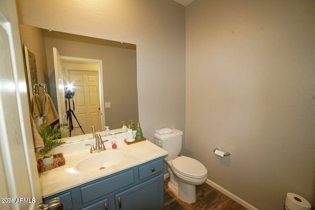 19886 W Woodlands Ave, Buckeye, AZ 85326 - bathroom with toilet, wood finished floors, vanity, and baseboards