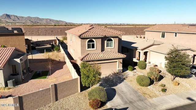 19886 W Woodlands Ave, Buckeye, AZ 85326 - view of front facade featuring a tile roof, concrete driveway, stucco siding, a mountain view, and central air condition unit
