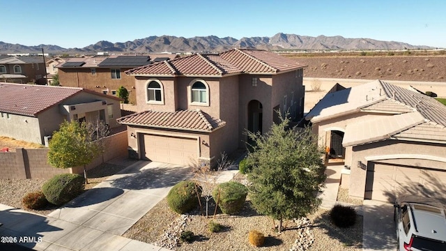 19886 W Woodlands Ave, Buckeye, AZ 85326 - mediterranean / spanish-style home featuring stucco siding, a mountain view, concrete driveway, a tile roof, and a residential view
