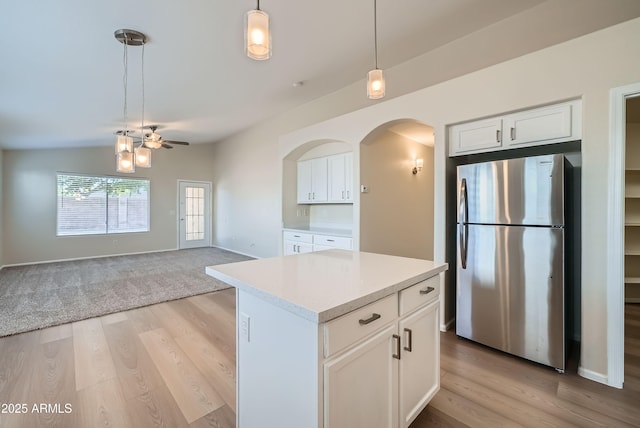 12333 W Marshall Ave, Litchfield Park, AZ 85340 - kitchen featuring white cabinets, arched walkways, decorative light fixtures, and freestanding refrigerator