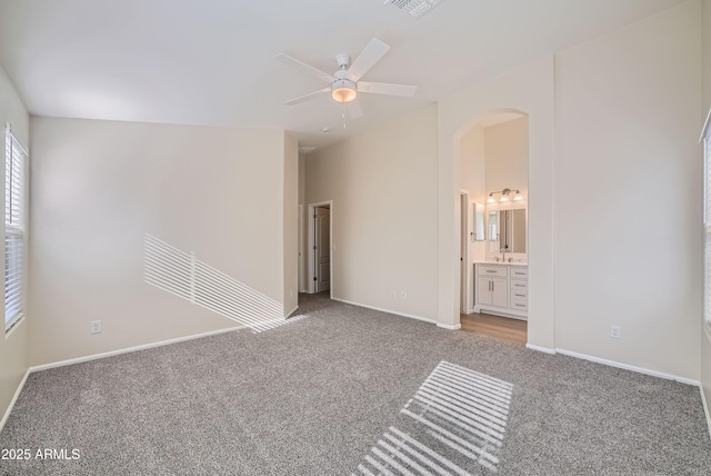 12333 W Marshall Ave, Litchfield Park, AZ 85340 - unfurnished bedroom with baseboards, connected bathroom, visible vents, arched walkways, and carpet