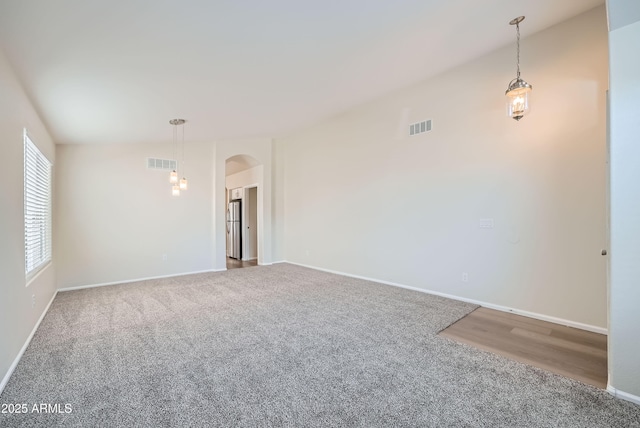 12333 W Marshall Ave, Litchfield Park, AZ 85340 - unfurnished room with arched walkways, carpet flooring, visible vents, and vaulted ceiling