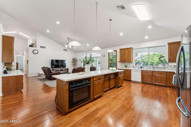 3750 E Palm St, Mesa, AZ 85215 - kitchen with oven, white dishwasher, a center island, open floor plan, and brown cabinetry