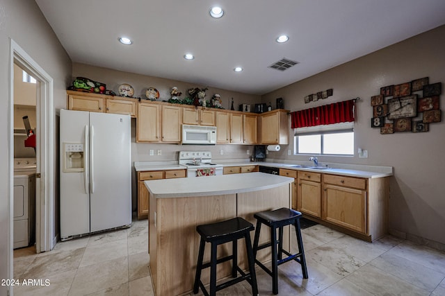 kitchen with white appliances, sink, a center island, a kitchen breakfast bar, and light brown cabinets