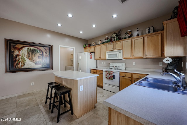 kitchen with white appliances, sink, a kitchen island, a kitchen breakfast bar, and light tile patterned floors