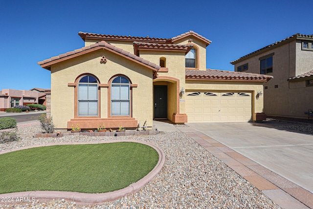 mediterranean / spanish-style house with a garage and a front lawn