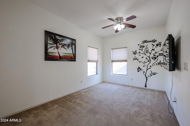 carpeted spare room featuring ceiling fan