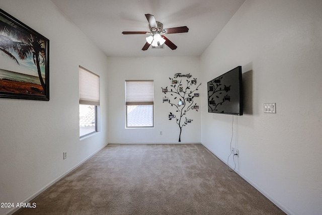 carpeted spare room with ceiling fan