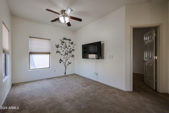 interior space with dark colored carpet and ceiling fan