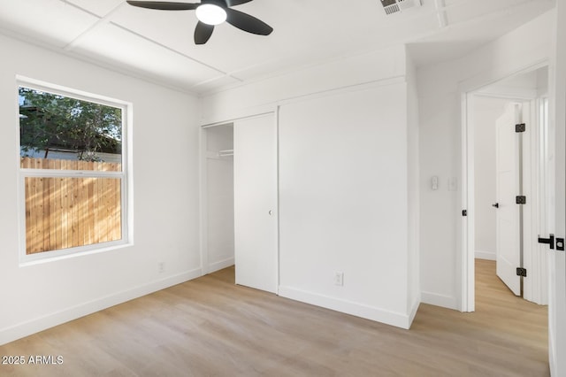 unfurnished bedroom featuring a closet, light hardwood / wood-style flooring, and ceiling fan