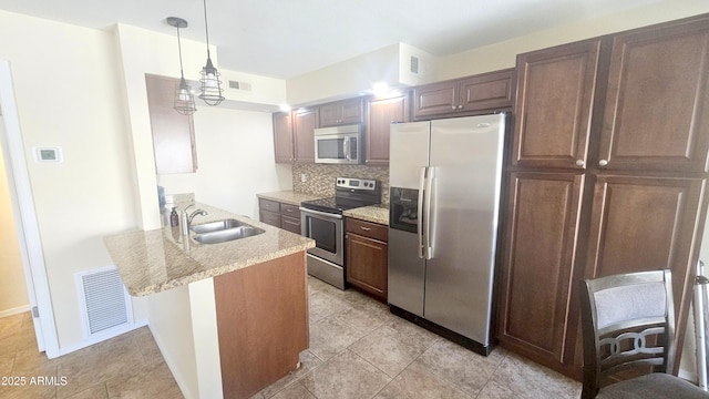14620 N Yerba Buena Way Unit B, Fountain Hills, AZ 85268 - kitchen featuring appliances with stainless steel finishes, a sink, tasteful backsplash, a peninsula, and pendant lighting