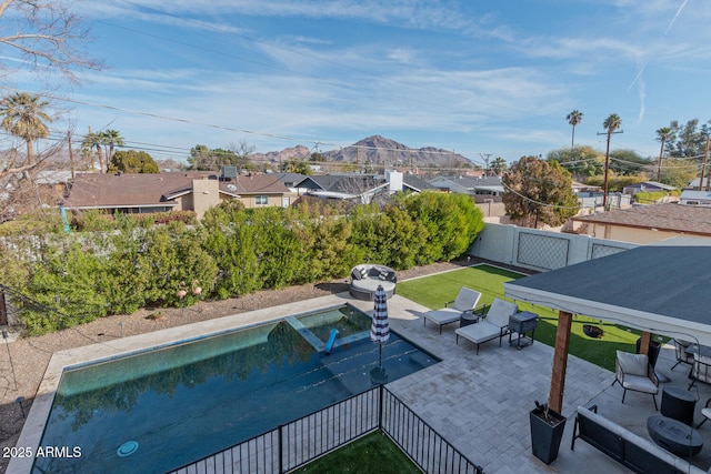 view of pool featuring a yard, a mountain view, and a patio area