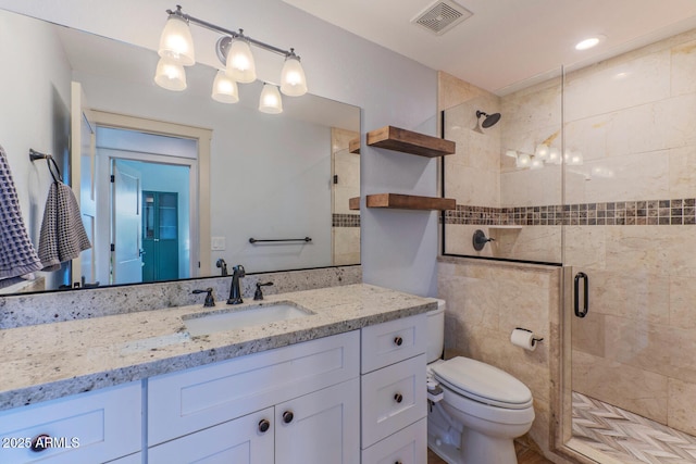 bathroom featuring vanity, an enclosed shower, and toilet