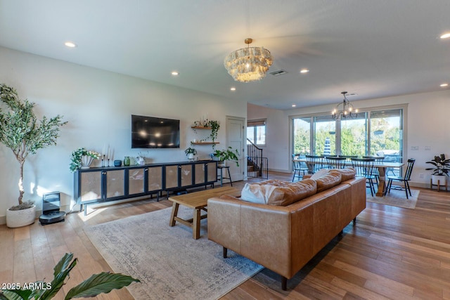 living room with light wood-type flooring and an inviting chandelier