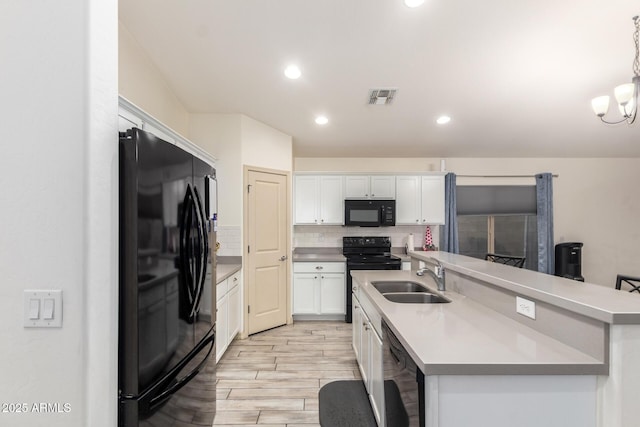 kitchen with decorative light fixtures, white cabinetry, sink, and black appliances