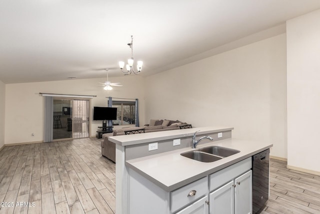 kitchen featuring vaulted ceiling, decorative light fixtures, black dishwasher, sink, and light hardwood / wood-style floors