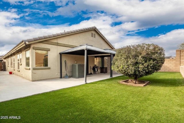 rear view of house with a patio, a yard, and central AC