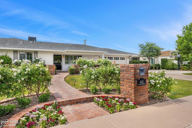 single story home with a shingled roof and an attached garage