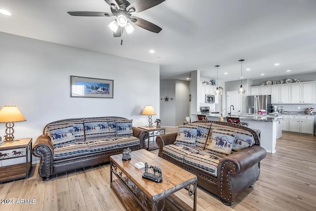 living room with ceiling fan and light wood-type flooring