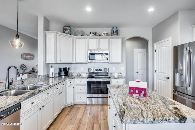 kitchen featuring white cabinets, sink, stainless steel appliances, and hanging light fixtures