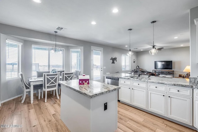 kitchen with white cabinets, hanging light fixtures, ceiling fan with notable chandelier, and light hardwood / wood-style floors