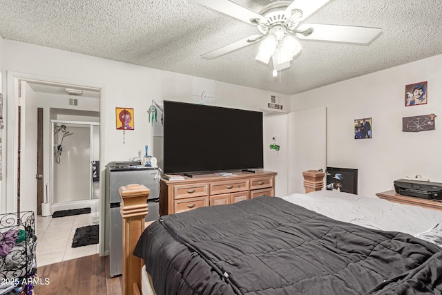 bedroom with a textured ceiling, wood finished floors, and a ceiling fan