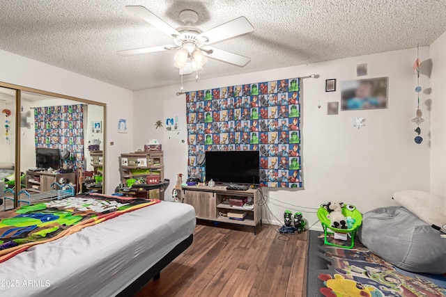 bedroom featuring a closet, a textured ceiling, ceiling fan, and wood finished floors