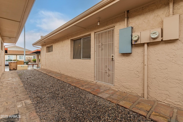 view of exterior entry with a patio area and stucco siding