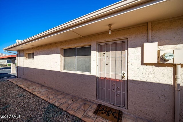 view of exterior entry with stucco siding