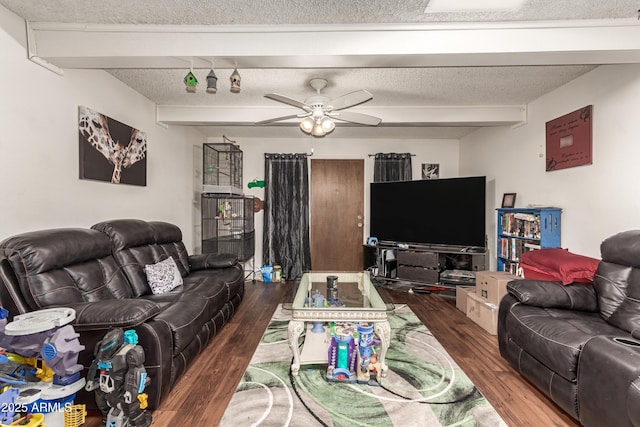 living room featuring a textured ceiling, a ceiling fan, beam ceiling, and wood finished floors