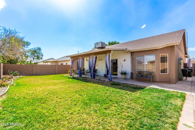 back of house with a lawn, a patio area, a fenced backyard, and stucco siding