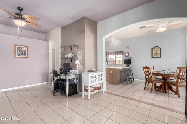 dining room featuring arched walkways, visible vents, a ceiling fan, light tile patterned flooring, and baseboards