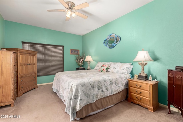 bedroom with light carpet, ceiling fan, and baseboards