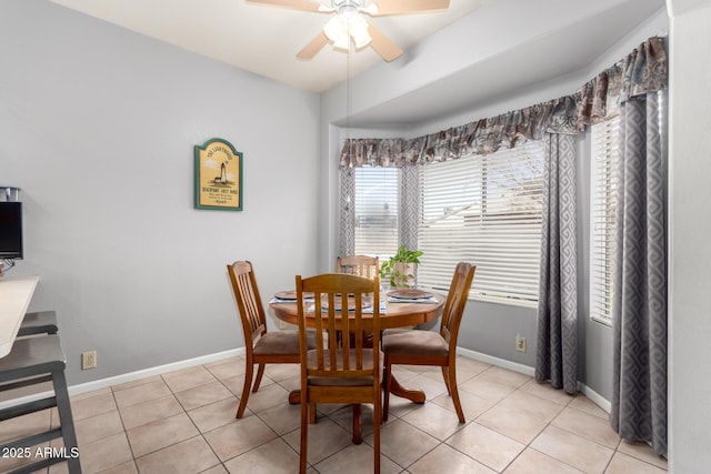 dining room with a ceiling fan, baseboards, and light tile patterned floors