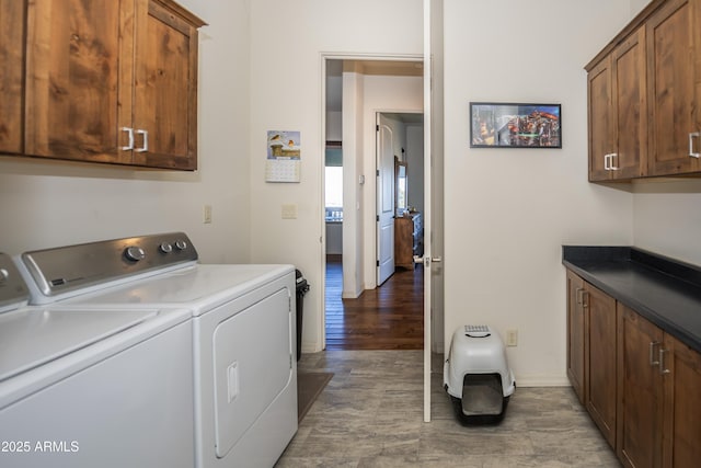 laundry room with dark hardwood / wood-style floors, cabinets, and washing machine and clothes dryer