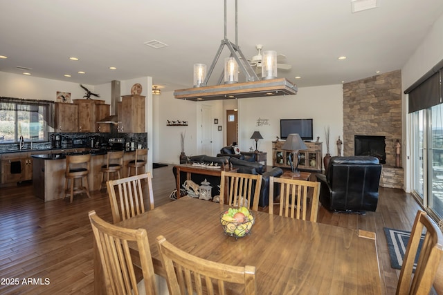 dining space featuring dark hardwood / wood-style floors, sink, and a fireplace